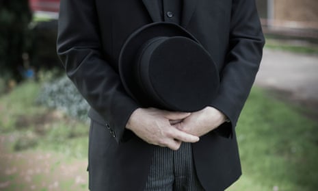 a funeral director holding a hat