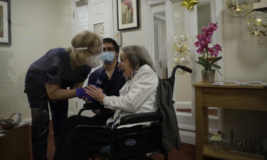 Care home resident Joan Potts, aged 102, speaks to Dr Jane Allen after receiving a Covid vaccine at the Wimbledon Beaumont Care Home in London