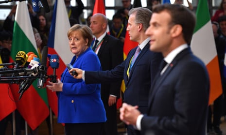 The German chancellor, Angela Merkel, looking at the French president, Emmanuel Macron, as they both conduct media interviews on arrival at the summit.