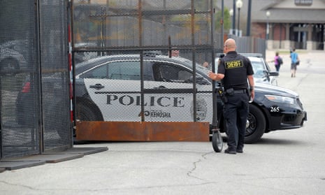 A Kenosha police vehicle exits the defensive perimeter that has been erected around the Kenosha Municipal Building in Kenosha, Wisconsin