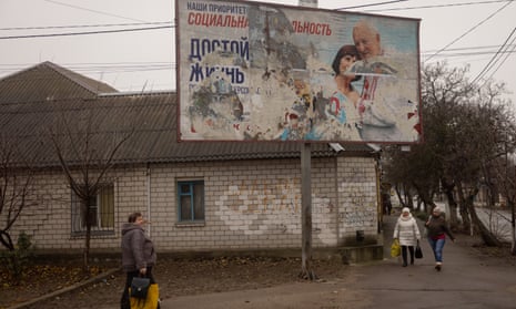 People walk past a destroyed Russian billboard on November 26, 2022 in Kherson, Ukraine.