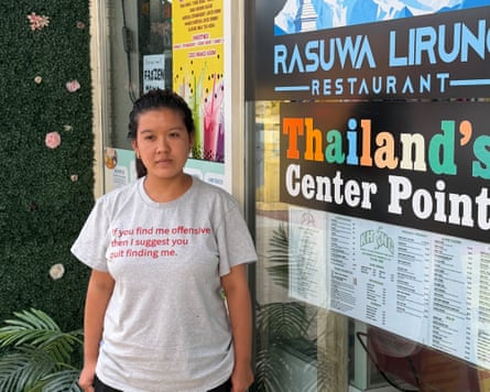 A young woman stands outside a restaurant.