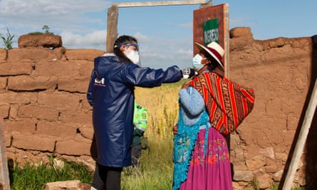 A government worker checks the temperature of a Quechua Indigenous voter in the village of Capachica, in Puno, Peru.