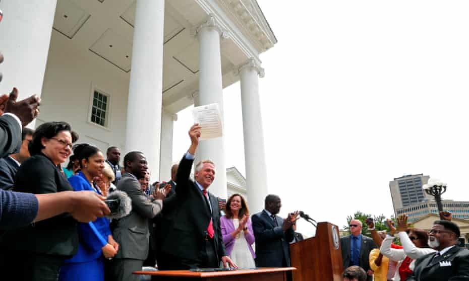 Virginia governor Terry McAuliffe holds up the order he signed to restore rights to felons in Virginia: ‘Virginia will no longer build barriers to the ballot box, we will break them down.’