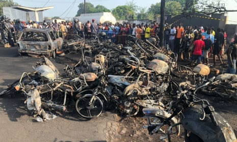 Crowd of people around burned car and motorcycles after a fuel tanker explosion in Freetown, Sierra Leone.