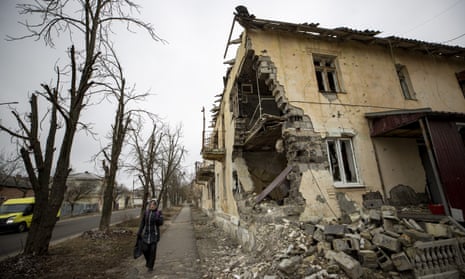 A woman walks past a destroyed residential building is seen in Izium, Ukraine on 13 January 2023.