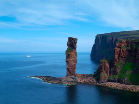Rock stack in the sea and distant ferry boat