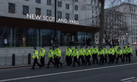 Officers march past New Scotland Yard in London following a protest against the handling of a vigil held for Sarah Everard on Clapham Common.