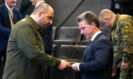 Ukraine’s defence minister, Rustem Umerov, left, hands a card to his Swedish counterpart, Pal Jonson, prior to a meeting of the Nato-Ukraine Council at Nato headquarters in Brussels.