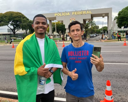Bolsonaro supporters Arley Xavier, 21, and Ronny de Souza, 43, stand outside the federal police base where Brazil’s former president Jaír Bolsonaro is serving his 27-year sentence