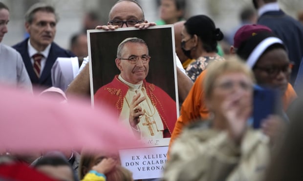 A man holds a photo of Pope John Paul I during the beatification ceremony