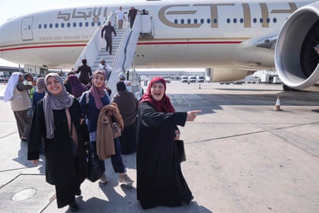 Palestinians evacuated from the Gaza Strip disembark from a plane arriving from Egypt into Abu Dhabi as part of a humanitarian mission organised by the United Arab Emirates.