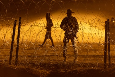armed law enforcement behind razor wire