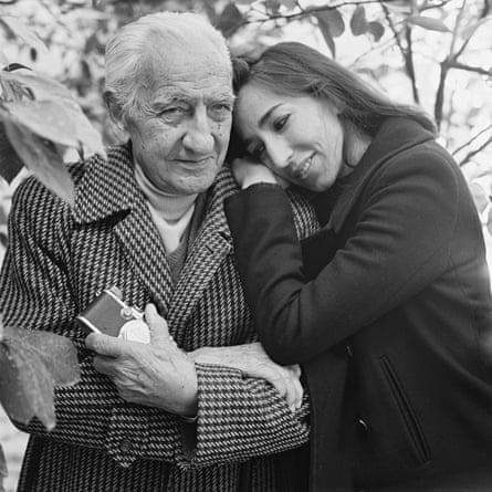 Black and white portrait of Paolo Di Paolo as an older man, wearing a check coat, with his adult daughter Silvia resting her head on his shoulder