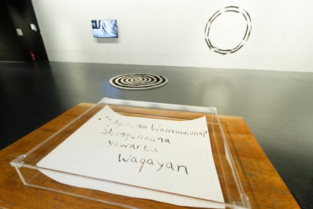 A piece of paper with dark, inky handwriting on it in Quechua is displayed in a clear box in the gallery.