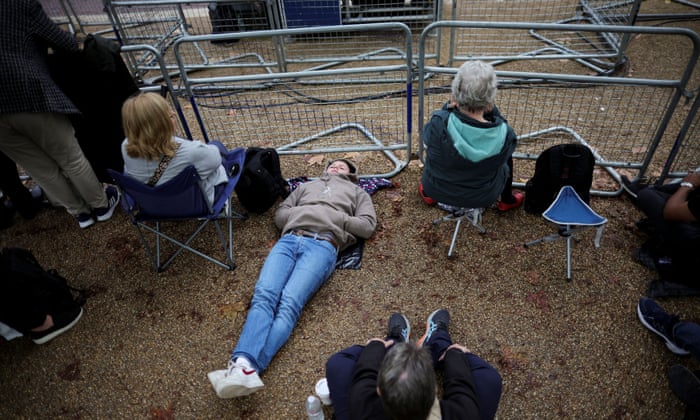 People gather at The Mall on the day the coffin of Queen Elizabeth is transported from Buckingham Palace to the Houses of Parliament for her lying in state.