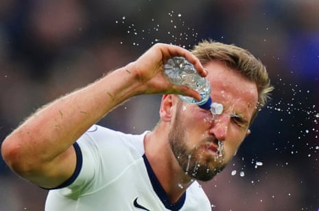 Harry Kane of Tottenham Hotspur splashes water on his face after being hit in the head by a free kick.