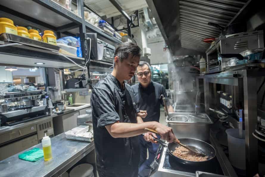 A chef makes spaghetti bolognese with plant-based OmniPork as David Yeung, the co-founder and co-chief executive officer of Green Monday, looks on at the Kind Kitchen restaurant in Hong Kong.