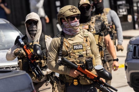 federal agents with guns stand outside