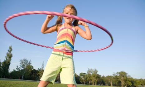 Six-year-old girl playing with hula hoop.