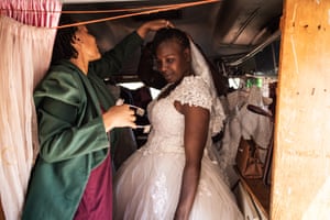 Daphne adjusts Memory's veil as she stands in a wedding dress