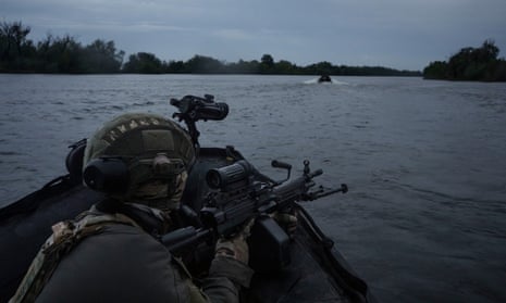 Ukrainian soldiers navigate on the Dnipro River by boat at the frontline near Kherson, Ukraine, in June 2023