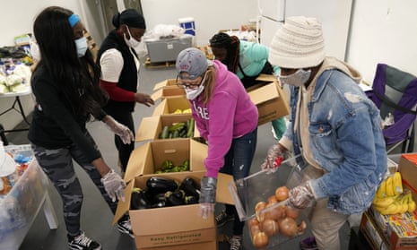 Sherina Jones, left, works with volunteers organizing food for distribution in December in the Liberty City neighborhood of Miami.
