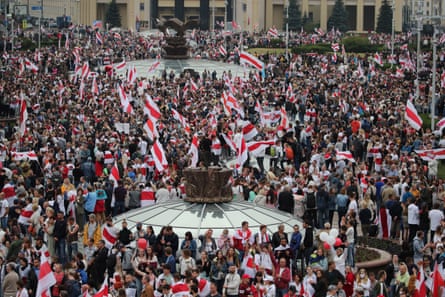 A crowd of people waving the white-red-white flag, the flag of the historic Belarusian Democratic Republic.