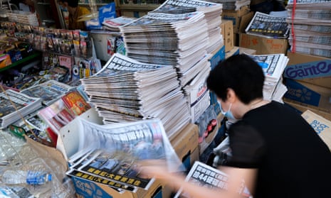 Employees at the newspaper stall sort out the newspapers of Apple Daily in Hong Kong