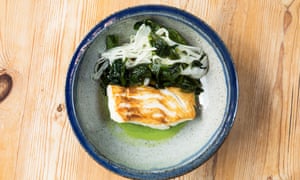 A dish with a rectangle of cod and cooked greens
