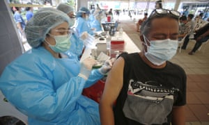 A health worker administers a dose of the Sinovac Covid-19 vaccine to residents of the Klong Toey area of Bangkok, Thailand.