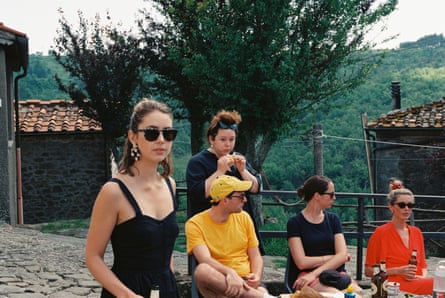 A group of women (and one man) in singlets and T-shirts with a forest behind them