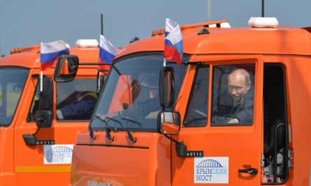 Putin sits in a dump truck before driving it on the newly opened bridge.