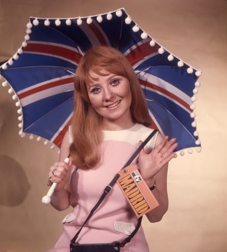 Lulu holding a union jack-patterned umbrella and a large tag with the word Madrid, before representing the UK in the Spain for 1969’s Eurovision