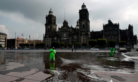 Workers disinfect and clean the Zocalo square in Mexico City on 29 June, 2020 during the Covid-19 pandemic.