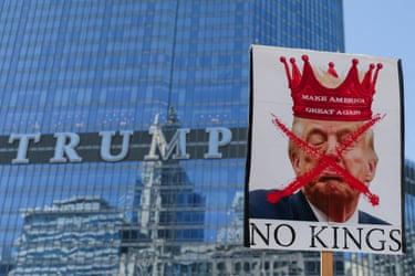 New York City, USA person holds a sign with an image depicting U.S. President Donald Trump as demonstrators walk past the Trump Tower