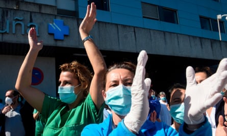 Healthcare workers dealing with the coronavirus crisis in A Coruña applaud in return as they are cheered on outside the city’s university hospital