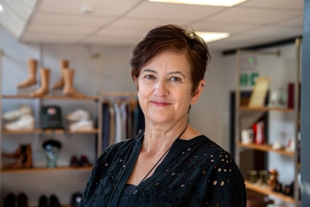 A woman with short dark hair wearing a black crochet dress in a store
