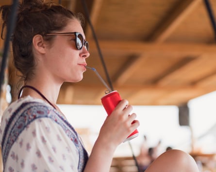 young woman sipping a canned drink