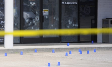 The windows of the Armed Forces Recruitment Center have several bullet holes from a shooting as the area is cordoned off with blue shell casing markers in the parking lot on Thursday in Chattanooga, Tennessee.