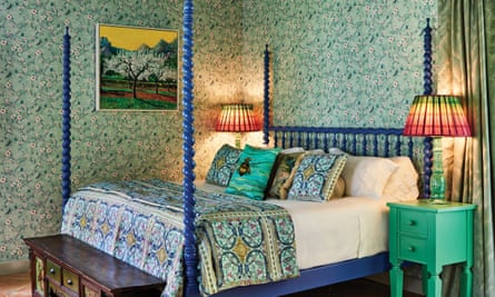 A bedroom with blue patterned bedding on a four-poster and green wallpaper at Suite 67 at Belmond La Residencia