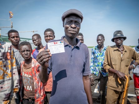 Peter Gatkuoth, 51, shows his registration card, that should allow him to board a boat to Malakal out of Renk. A teacher by profession, he had escaped the South Sudanese civil war in 2014 and sought refuge in Khartoum, where he has been working as a teacher. Now that he has been forced to leave Khartoum, he hopes to find work once he returns to Malakal but worries about political instability in South Sudan.