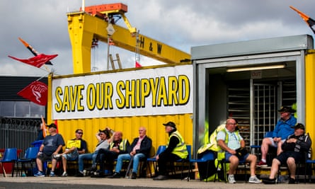 Harland and Wolff workers sit beneath a large banner saying Save Our Shipyard