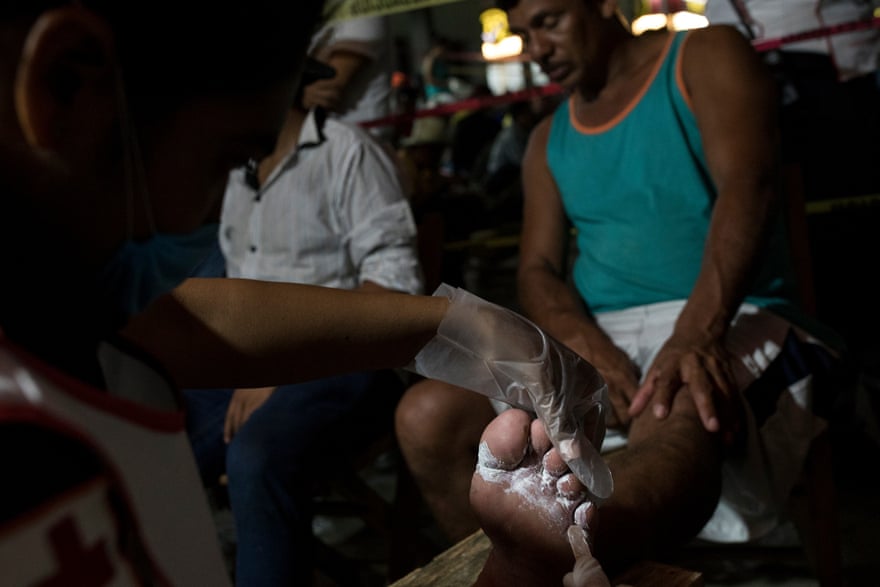 Men getting their feet looked after - migrants walk for hours and hours every day.