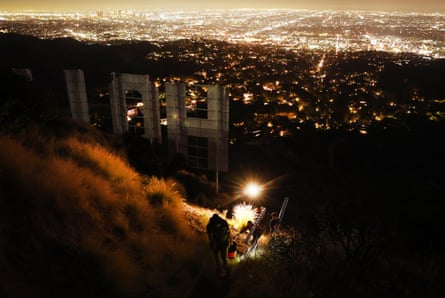 Equipment is carried away from the Hollywood sign on the 100th anniversary of it first being illuminated, 8 December in Los Angeles, California