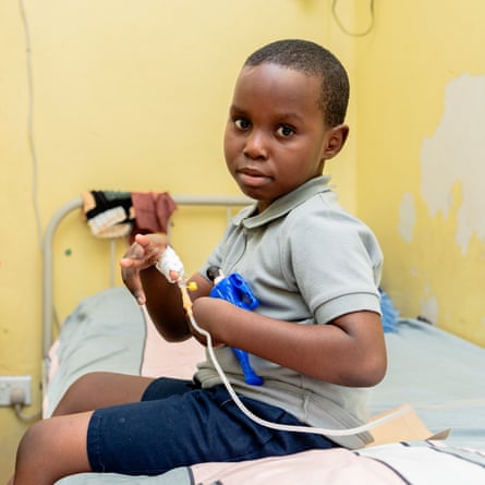 Emmanuel Muwowo, eight, sitting on his hospital bed as he receives treatment for sickle cell in Lusaka, Zambia