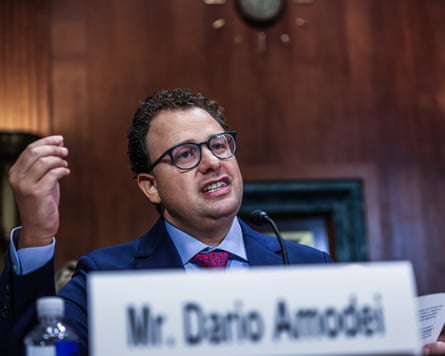 person wearing glasses gestures while speaking into small microphone