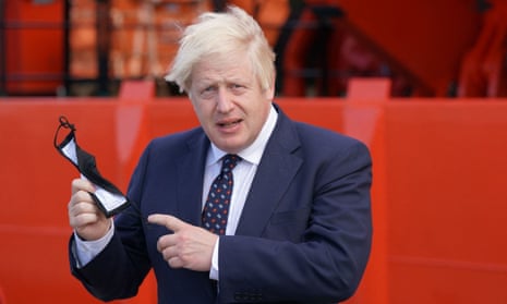 Boris Johnson holds his face mask before boarding a boat to an offshore windfarm in Scotland on Thursday.