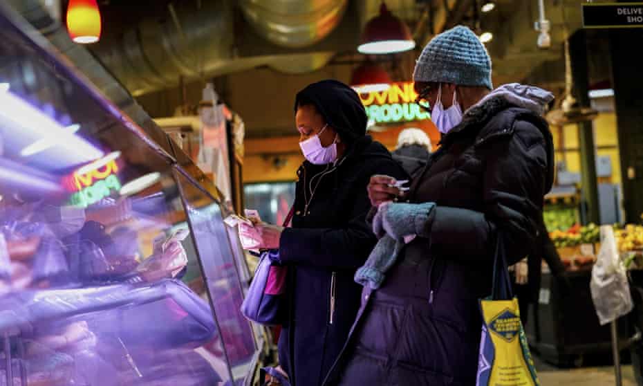 Customers wear face masks to protect against the spread of the coronavirus as they shop at the Reading Terminal Market in Philadelphia on 16 February 2022.