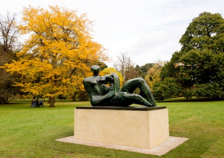 A sculpture on a plinth in a garden.